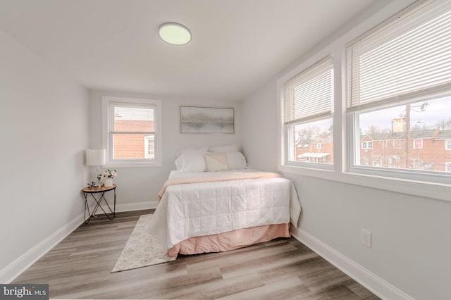 bedroom with baseboards and wood finished floors