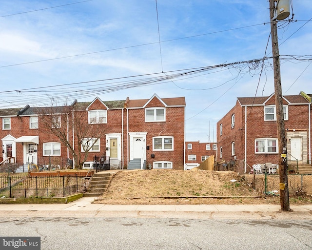 view of property with a fenced front yard and brick siding