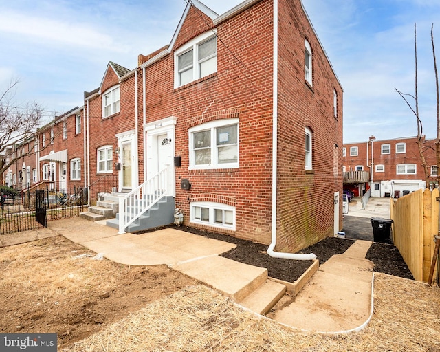 view of property with fence and brick siding