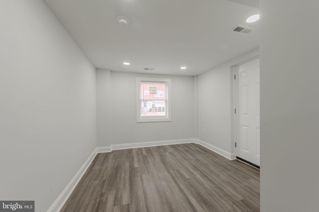 unfurnished room with recessed lighting, wood finished floors, visible vents, and baseboards