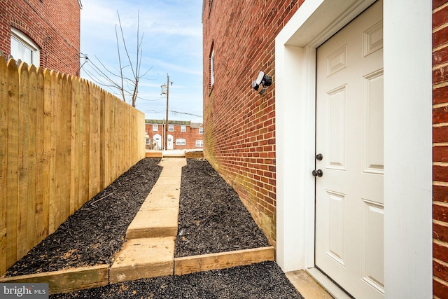 exterior space featuring brick siding and fence