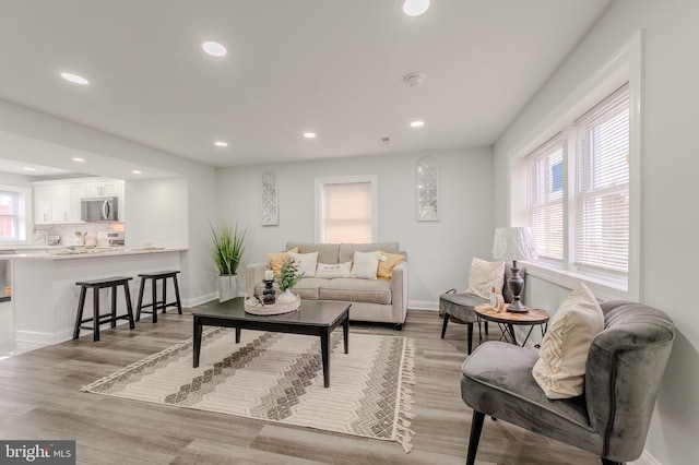 living area featuring recessed lighting, light wood-style flooring, and baseboards