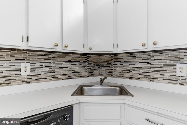 kitchen featuring tasteful backsplash, dishwasher, light countertops, and a sink