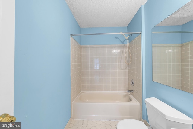 full bathroom with tile patterned flooring, bathing tub / shower combination, toilet, and a textured ceiling