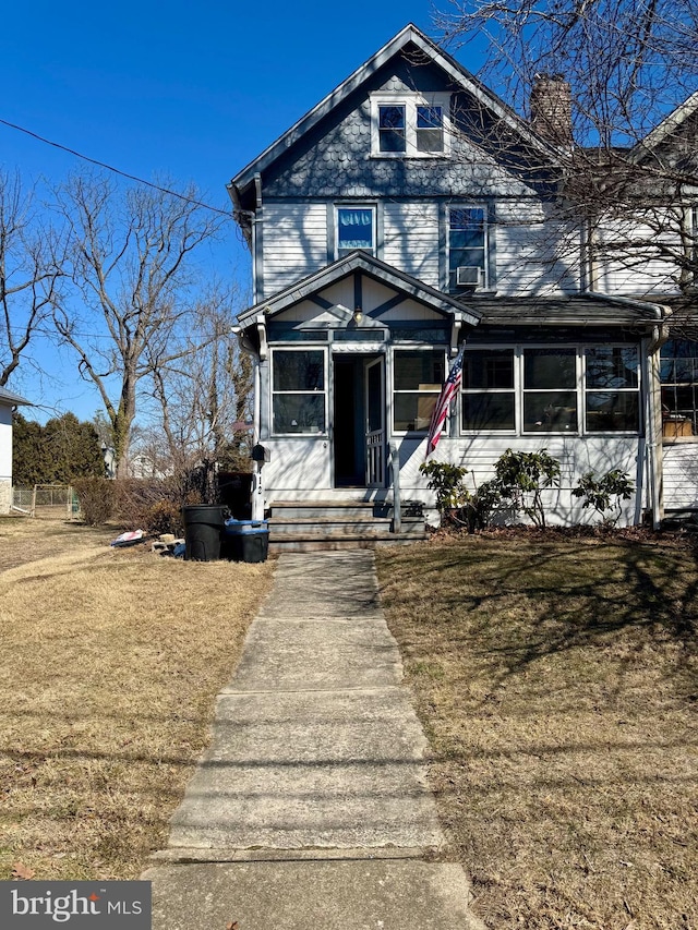 traditional style home with a front yard and a chimney