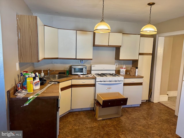 kitchen featuring a sink, a toaster, gas range gas stove, and hanging light fixtures