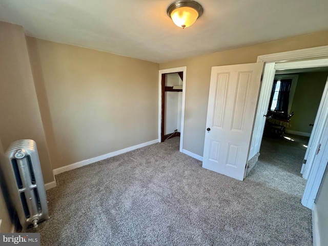 unfurnished bedroom featuring radiator, baseboards, and carpet flooring