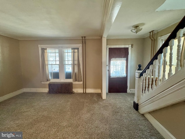 entryway with carpet floors, baseboards, stairway, radiator, and crown molding