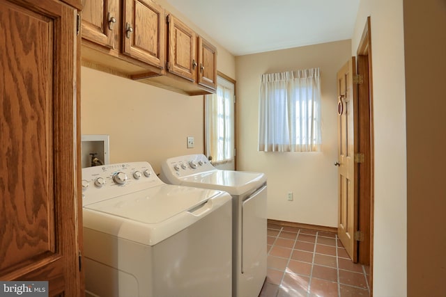 washroom featuring cabinet space, washer and clothes dryer, baseboards, and light tile patterned flooring