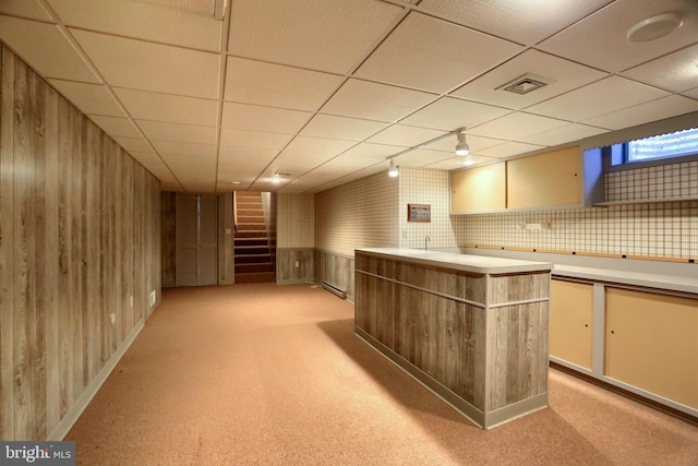 bar with light carpet, visible vents, stairway, a paneled ceiling, and wood walls