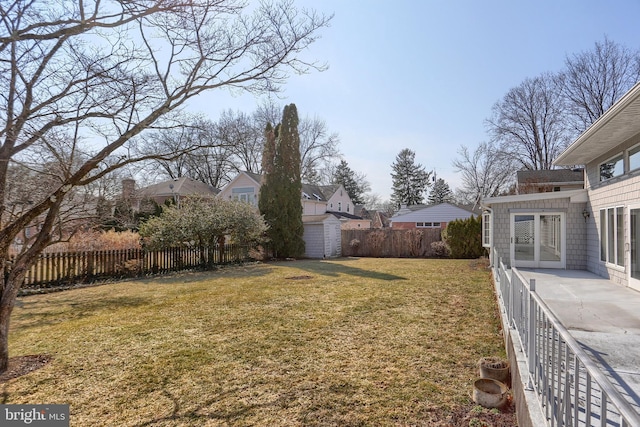 view of yard with an outbuilding, a patio, a storage unit, and a fenced backyard