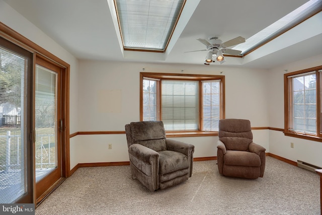 living area featuring baseboards, a baseboard heating unit, and light colored carpet