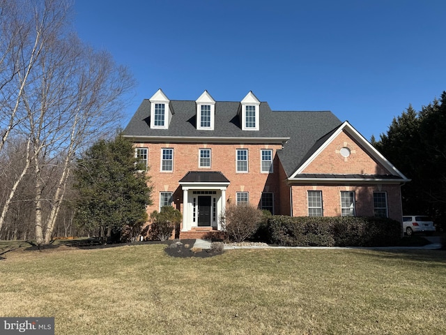 view of front facade featuring brick siding and a front yard