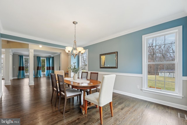 dining space featuring ornamental molding, visible vents, decorative columns, and wood finished floors