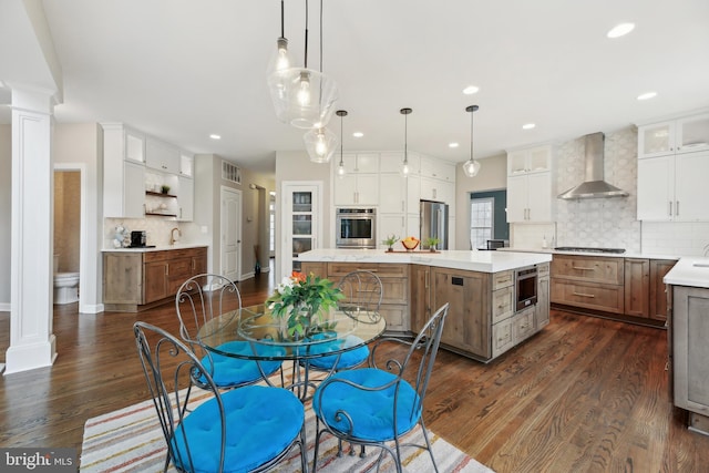 dining area with dark wood-style floors, recessed lighting, visible vents, and ornate columns