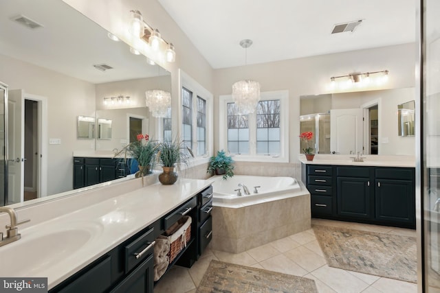 bathroom featuring tile patterned floors, visible vents, a sink, and a bath