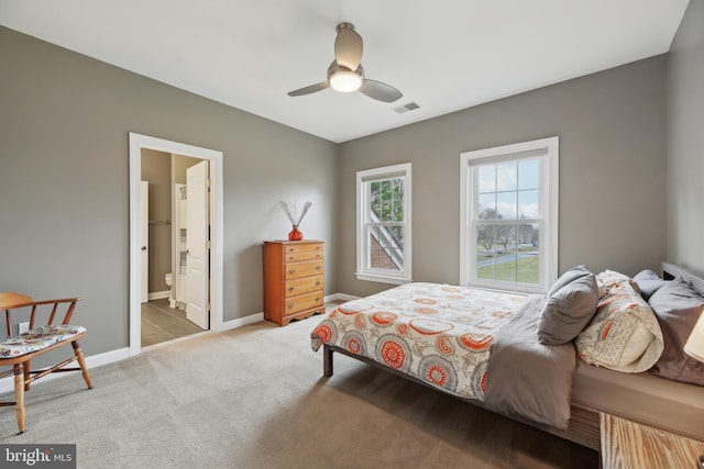 bedroom with ceiling fan, connected bathroom, light carpet, visible vents, and baseboards