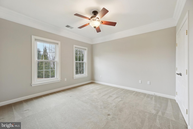 spare room featuring baseboards, visible vents, light colored carpet, ceiling fan, and crown molding