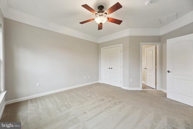 unfurnished bedroom with ornamental molding, carpet, a closet, and baseboards