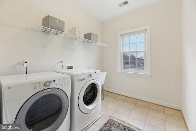 laundry area with laundry area, baseboards, visible vents, washer and dryer, and light tile patterned flooring