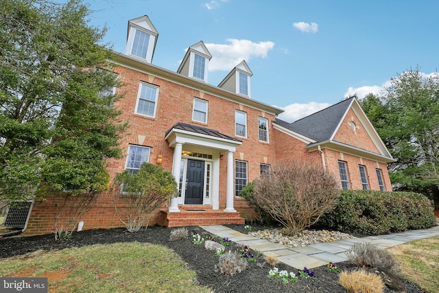 colonial inspired home with brick siding