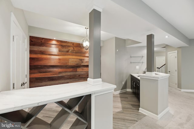 bar featuring an inviting chandelier, baseboards, stairway, and pendant lighting