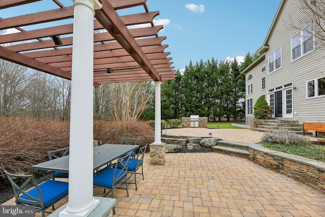 view of patio with entry steps, outdoor dining area, an outdoor kitchen, and a pergola