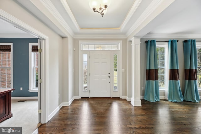 entryway with ornate columns, baseboards, ornamental molding, and wood finished floors