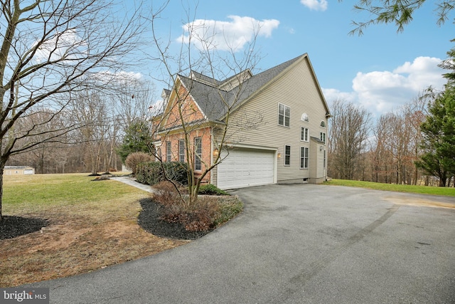 view of side of home with a garage, aphalt driveway, a lawn, and brick siding