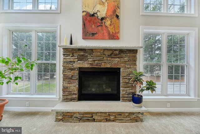 interior details featuring carpet floors, a fireplace, and baseboards