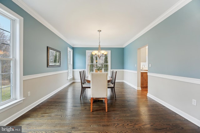 dining room featuring ornamental molding, dark wood-style flooring, baseboards, and an inviting chandelier