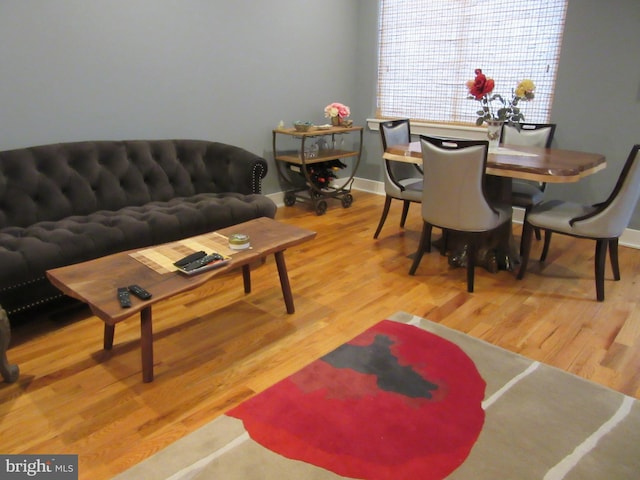 living area with light wood-style flooring and baseboards