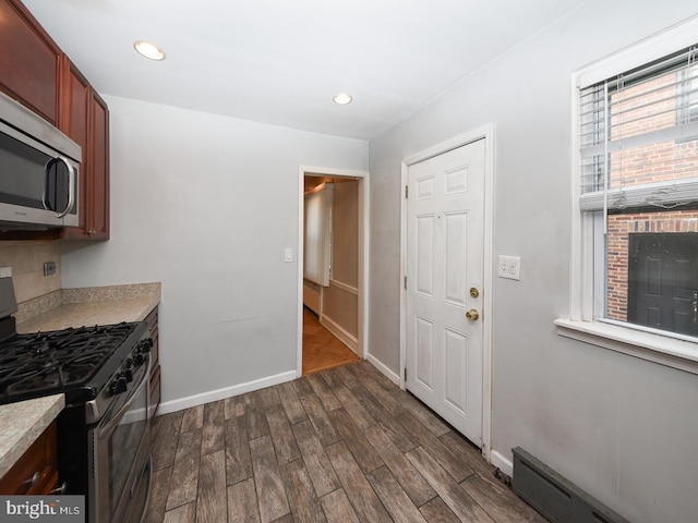 kitchen featuring dark wood-style floors, stainless steel appliances, recessed lighting, light countertops, and baseboards