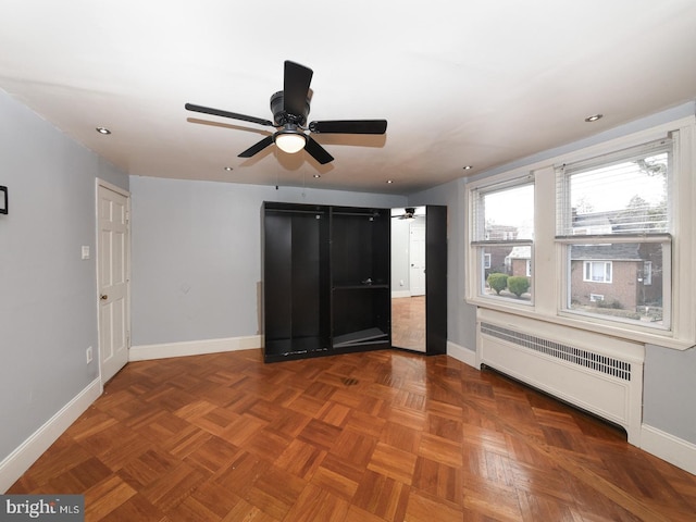 interior space with radiator heating unit, recessed lighting, a ceiling fan, and baseboards