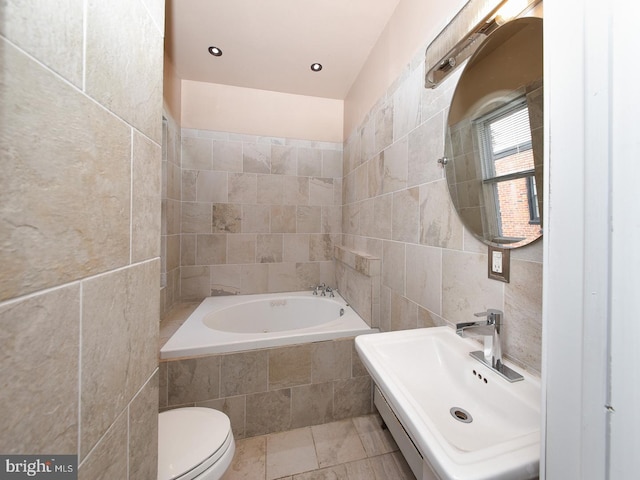 full bathroom with toilet, tiled tub, tile walls, and a sink