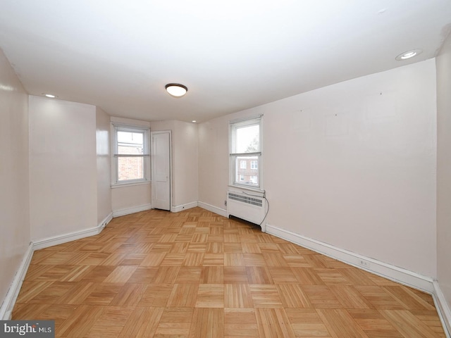 empty room featuring radiator heating unit and baseboards