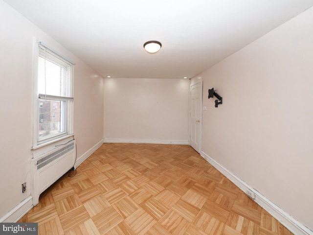 unfurnished room with radiator and baseboards