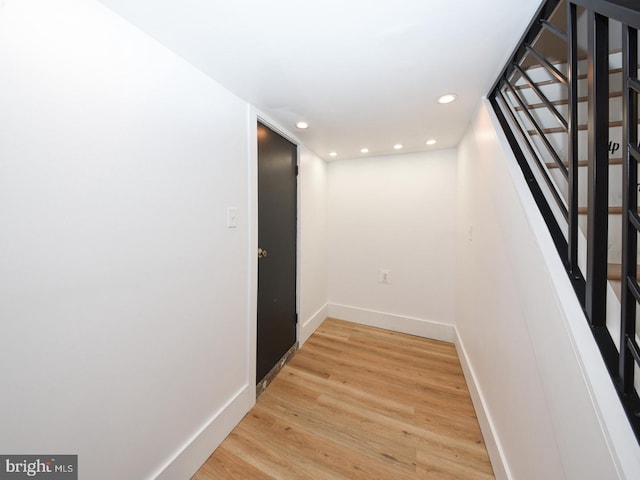 corridor with stairs, recessed lighting, baseboards, and light wood-style floors