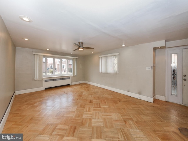 unfurnished room with ceiling fan, radiator heating unit, recessed lighting, and baseboards