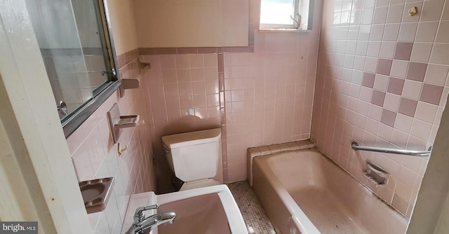 bathroom featuring toilet and tile walls