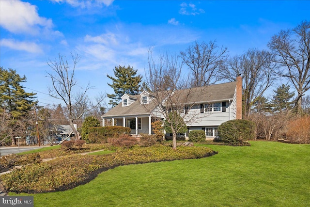 view of front facade featuring a chimney and a front yard