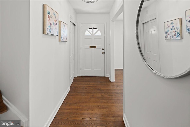 doorway to outside featuring dark wood-style flooring and baseboards