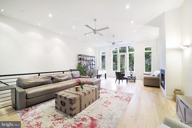 living area with stairway, light wood-style flooring, and recessed lighting