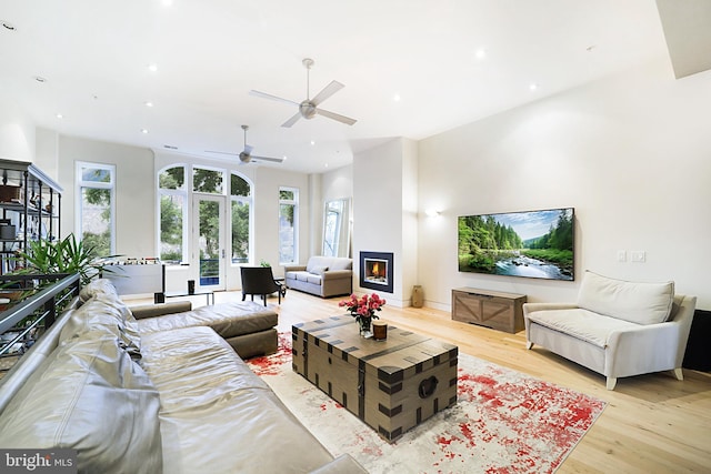 living area with plenty of natural light, a lit fireplace, wood finished floors, and recessed lighting