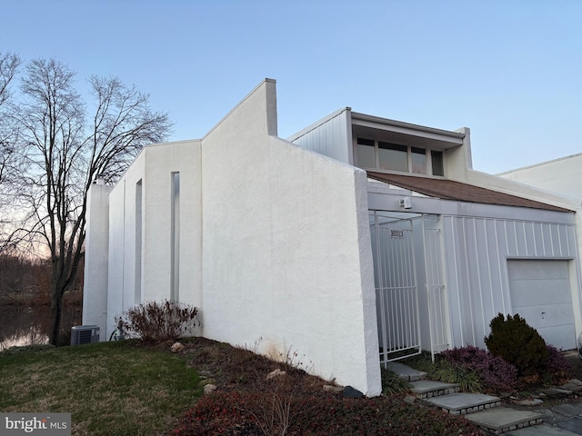 view of home's exterior with central AC and stucco siding