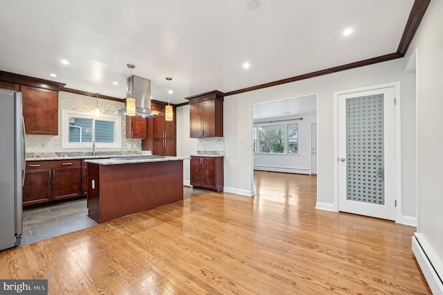 kitchen featuring a baseboard radiator, a center island, freestanding refrigerator, and island range hood