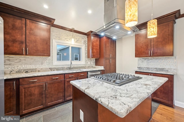 kitchen featuring stainless steel appliances, exhaust hood, a sink, and light stone counters