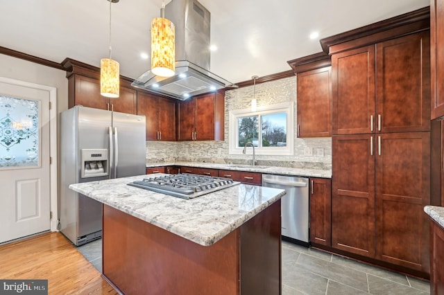 kitchen with crown molding, appliances with stainless steel finishes, a sink, island range hood, and light stone countertops