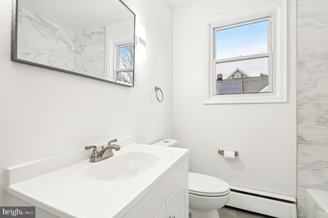 full bathroom featuring a baseboard heating unit, vanity, toilet, and a bath