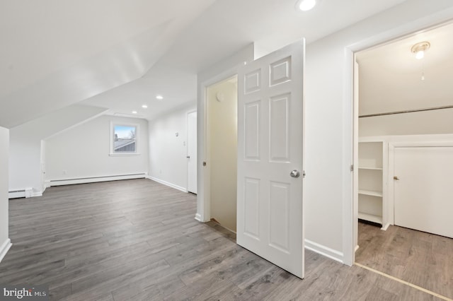 bonus room with a baseboard heating unit, baseboard heating, wood finished floors, and recessed lighting